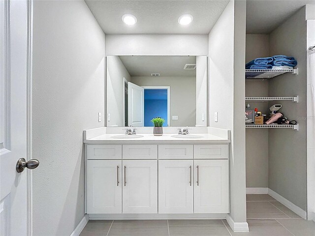 32451 Limitless Pl, Wesley Chapel, FL 33545 - bathroom featuring double vanity, tile patterned floors, and baseboards