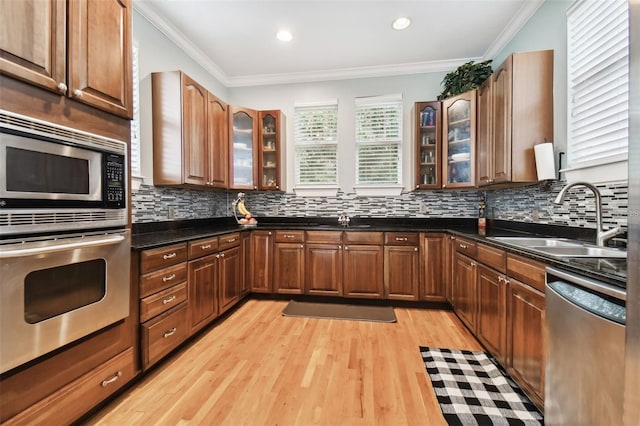 3104 W Fielder St, Tampa, FL 33611 - kitchen with stainless steel appliances, a sink, light wood-type flooring, backsplash, and ornamental molding