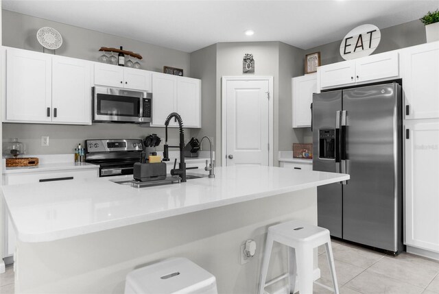 14532 Whitewater Way, Brooksville, FL 34604 - kitchen featuring stainless steel appliances, white cabinetry, an island with sink, a kitchen bar, and light countertops