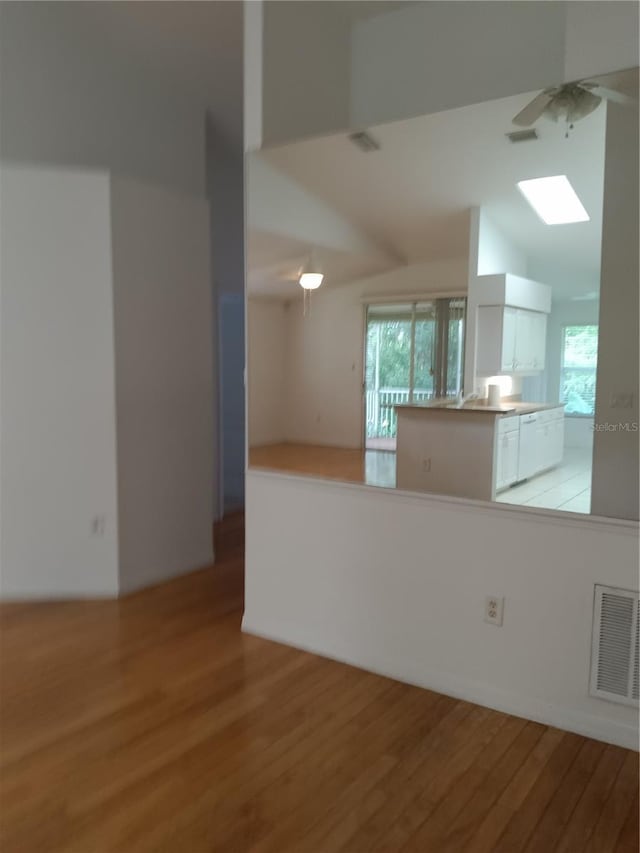 1605 Send Way, Lutz, FL 33549 - kitchen with wood finished floors, ceiling fan, a skylight, and white cabinets