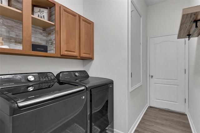 13910 Chalk Hill Pl, Riverview, FL 33579 - laundry room with cabinet space, washer and clothes dryer, wood finished floors, and baseboards