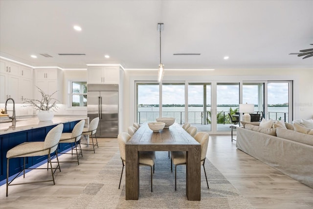 820 Bay Point Dr, Madeira Beach, FL 33708 - dining area with recessed lighting, light wood finished floors, crown molding, and a water view