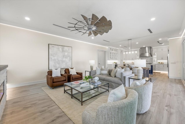 820 Bay Point Dr, Madeira Beach, FL 33708 - living area featuring recessed lighting, light wood-type flooring, a ceiling fan, baseboards, and a fireplace