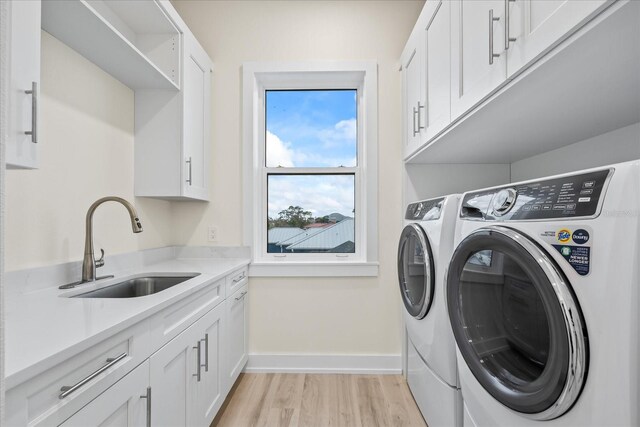 820 Bay Point Dr, Madeira Beach, FL 33708 - laundry room with cabinet space, separate washer and dryer, light wood finished floors, and baseboards