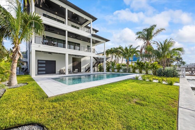 820 Bay Point Dr, Madeira Beach, FL 33708 - back of house with a ceiling fan, stairway, a balcony, a patio, and an outdoor pool