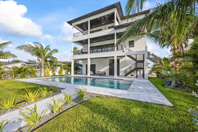 820 Bay Point Dr, Madeira Beach, FL 33708 - rear view of property with a balcony, stairs, a ceiling fan, and a yard