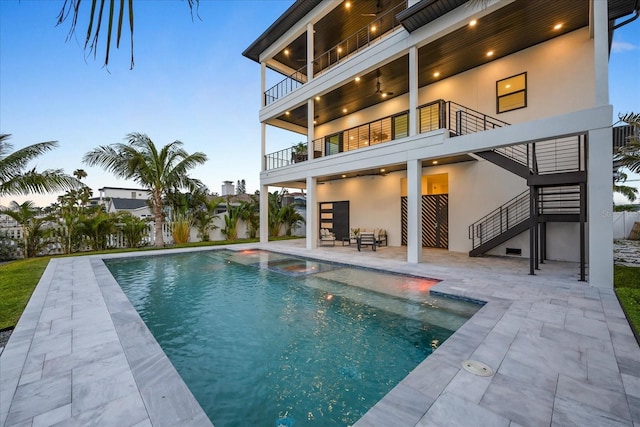 820 Bay Point Dr, Madeira Beach, FL 33708 - rear view of property with stairway, a balcony, a patio, stucco siding, and a pool with connected hot tub