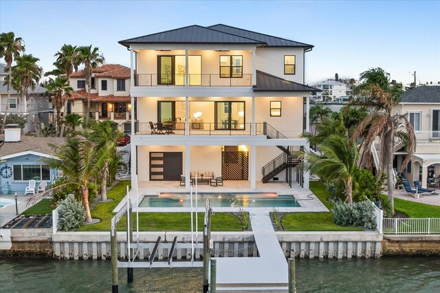 820 Bay Point Dr, Madeira Beach, FL 33708 - rear view of property featuring a balcony, a standing seam roof, stairs, metal roof, and stucco siding