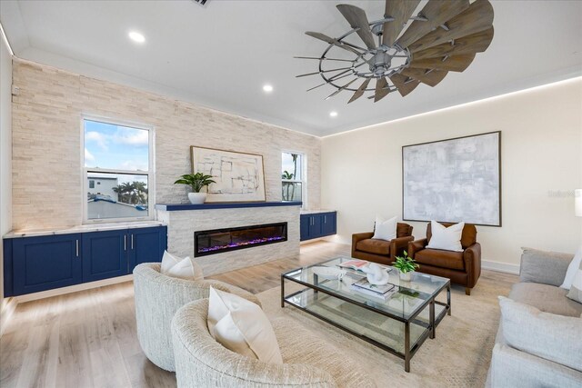 820 Bay Point Dr, Madeira Beach, FL 33708 - living room featuring ceiling fan, light wood-style floors, a glass covered fireplace, and recessed lighting