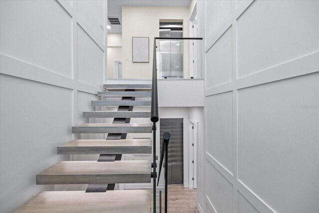 820 Bay Point Dr, Madeira Beach, FL 33708 - stairway featuring a decorative wall and wood finished floors