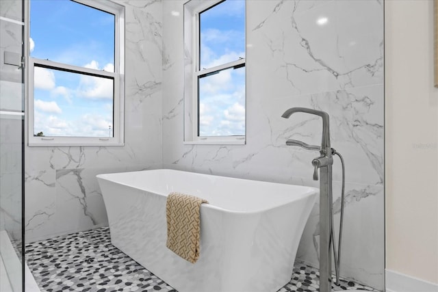 820 Bay Point Dr, Madeira Beach, FL 33708 - bathroom with a soaking tub, a marble finish shower, and tile walls