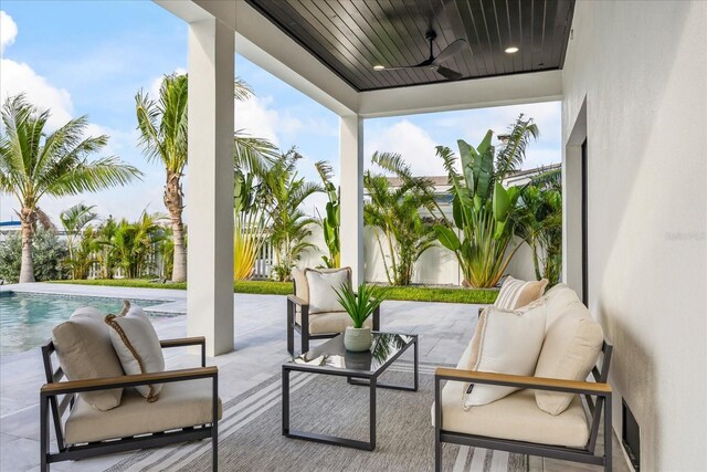 820 Bay Point Dr, Madeira Beach, FL 33708 - fenced backyard featuring outdoor lounge area, a ceiling fan, a patio area, and an outdoor pool