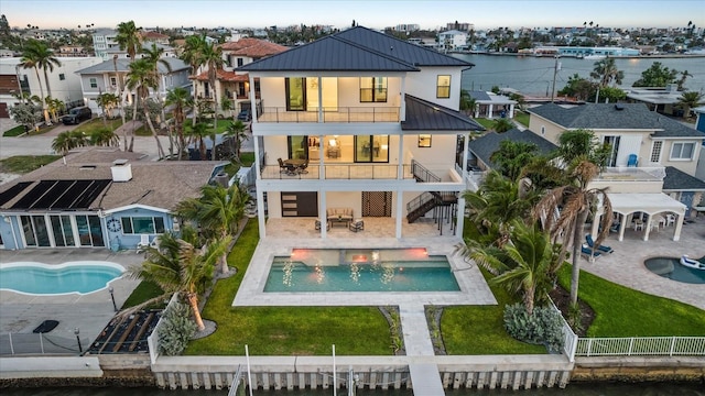 820 Bay Point Dr, Madeira Beach, FL 33708 - rear view of property featuring a standing seam roof, a balcony, metal roof, stairs, and a residential view