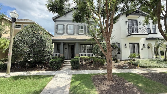 7810 Whitemarsh Way, Reunion, FL 34747 - view of front facade with a balcony, french doors, stucco siding, and a porch