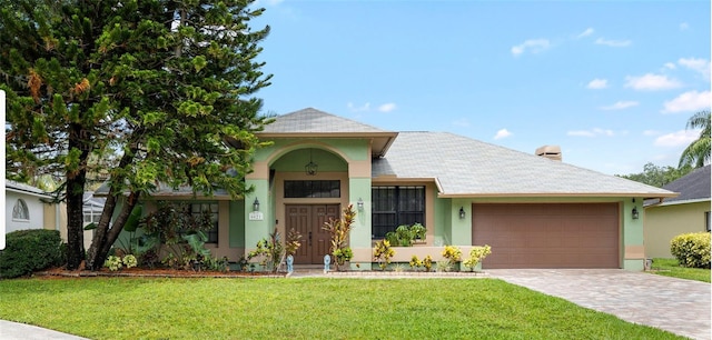 6621 Appaloosa Dr, Tampa, FL 33625 - view of front facade featuring a garage, stucco siding, a front yard, and driveway