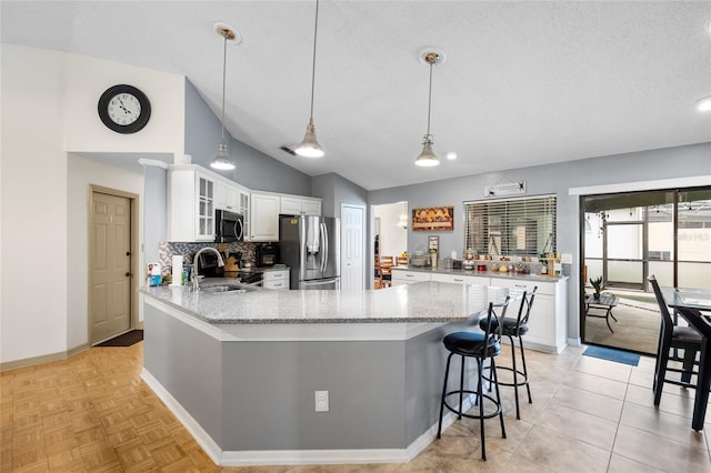 6621 Appaloosa Dr, Tampa, FL 33625 - kitchen with appliances with stainless steel finishes, a peninsula, vaulted ceiling, a sink, and glass insert cabinets