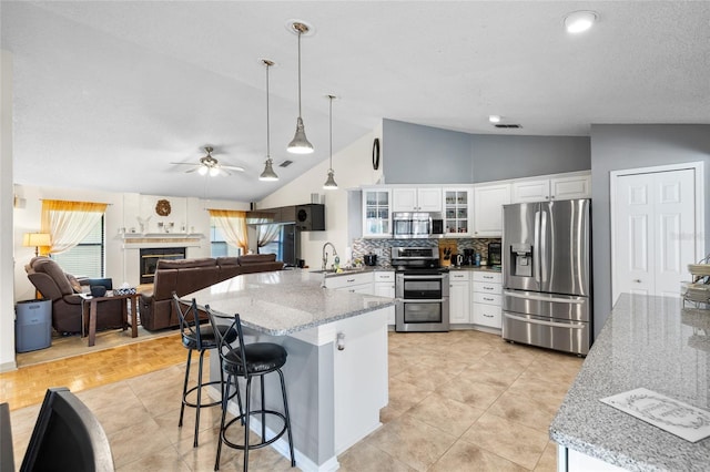 6621 Appaloosa Dr, Tampa, FL 33625 - kitchen featuring appliances with stainless steel finishes, a peninsula, a breakfast bar, open floor plan, and tasteful backsplash
