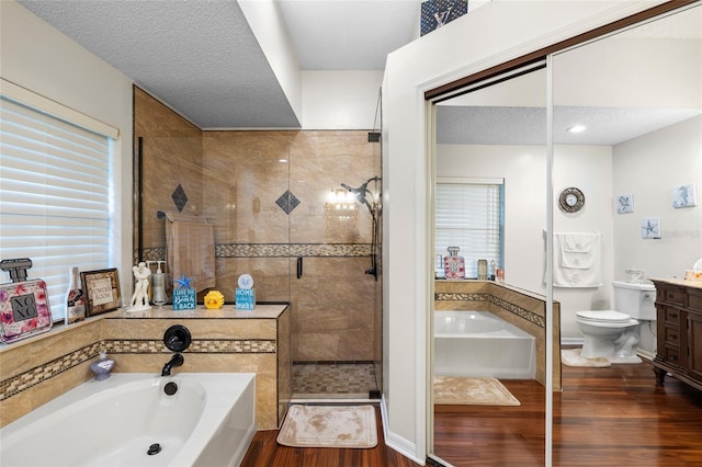 6621 Appaloosa Dr, Tampa, FL 33625 - bathroom featuring vanity, a garden tub, a shower stall, wood finished floors, and toilet