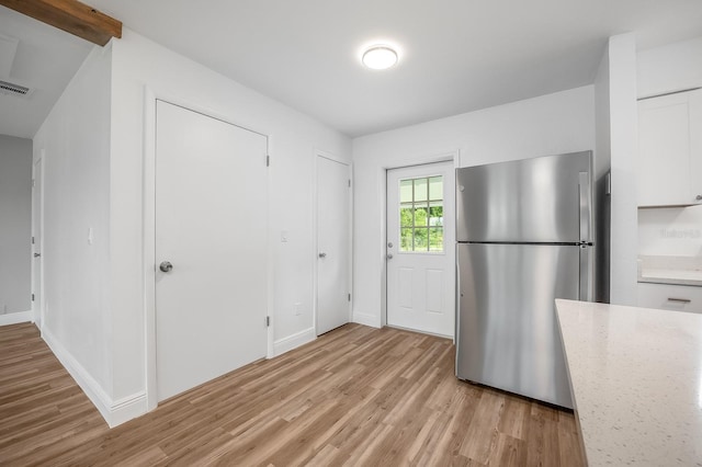 109 Magnolia Ave, Seffner, FL 33584 - kitchen featuring freestanding refrigerator, light wood-style flooring, white cabinets, and light stone counters