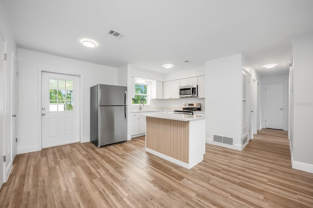 109 Magnolia Ave, Seffner, FL 33584 - kitchen featuring stainless steel appliances, light countertops, light wood-style flooring, and a kitchen island