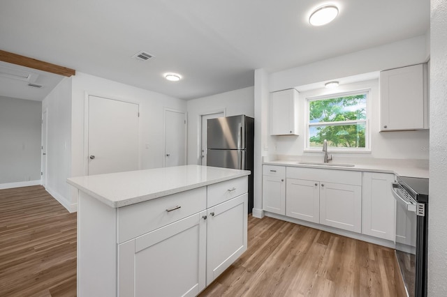 109 Magnolia Ave, Seffner, FL 33584 - kitchen featuring stainless steel appliances, light wood finished floors, white cabinetry, and light countertops