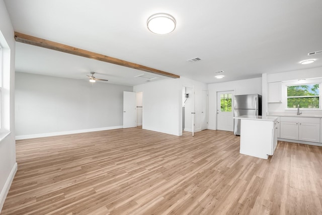109 Magnolia Ave, Seffner, FL 33584 - unfurnished living room featuring healthy amount of natural light, light wood-style flooring, and a ceiling fan