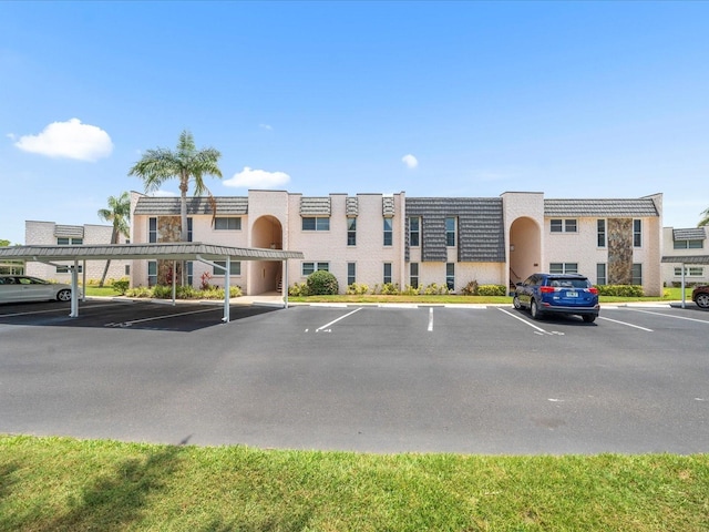 213 Fernwood Cir Unit 213, Seminole, FL 33777 - view of building exterior featuring covered and uncovered parking