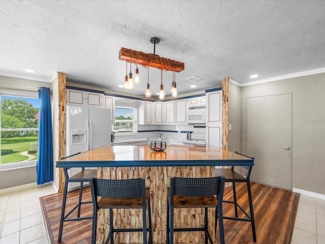 213 Fernwood Cir Unit 213, Seminole, FL 33777 - kitchen featuring white appliances, plenty of natural light, a sink, ornamental molding, and tile patterned flooring