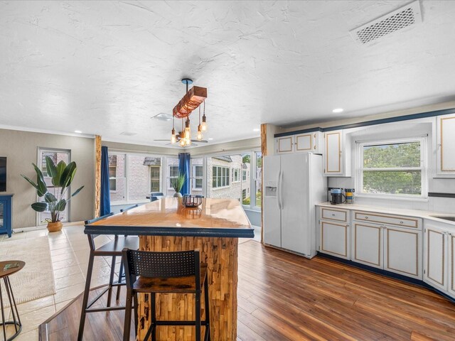 213 Fernwood Cir Unit 213, Seminole, FL 33777 - kitchen with white refrigerator with ice dispenser, dark wood-style floors, light countertops, a chandelier, and a center island