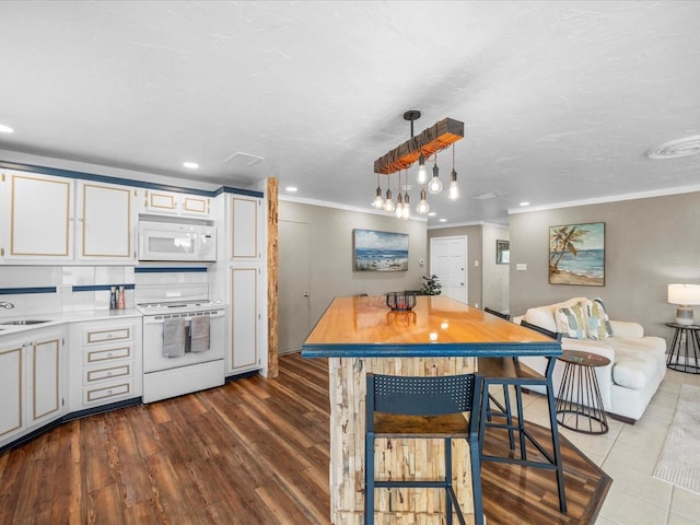 213 Fernwood Cir Unit 213, Seminole, FL 33777 - kitchen with white appliances, crown molding, light countertops, wood finished floors, and white cabinetry