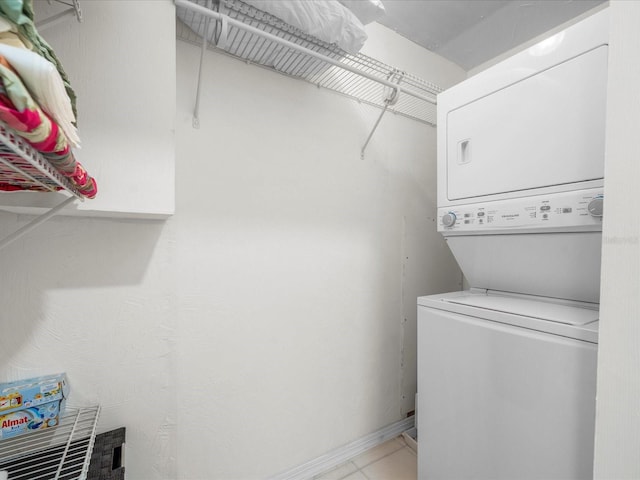 213 Fernwood Cir Unit 213, Seminole, FL 33777 - laundry area with stacked washer / dryer, light tile patterned floors, and baseboards