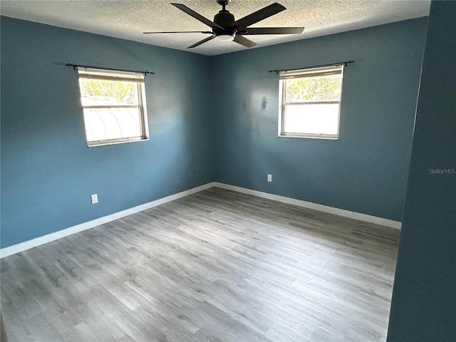 715 2nd Ave NE, Largo, FL 33770 - unfurnished room featuring a textured ceiling, plenty of natural light, ceiling fan, and wood finished floors