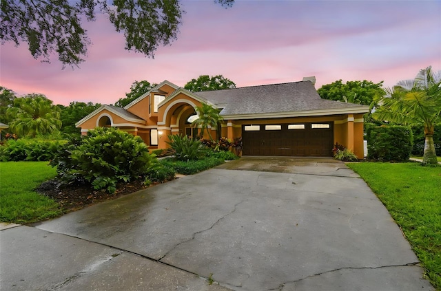 3308 Landing Pl, Palm Harbor, FL 34684 - view of front of home featuring a garage, a lawn, concrete driveway, and stucco siding