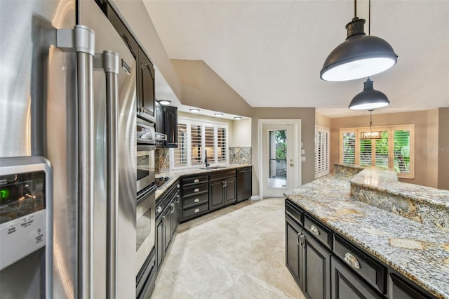 3308 Landing Pl, Palm Harbor, FL 34684 - kitchen featuring appliances with stainless steel finishes, a sink, backsplash, pendant lighting, and light stone countertops
