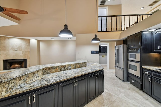3308 Landing Pl, Palm Harbor, FL 34684 - kitchen with appliances with stainless steel finishes, a towering ceiling, a ceiling fan, hanging light fixtures, and dark cabinets