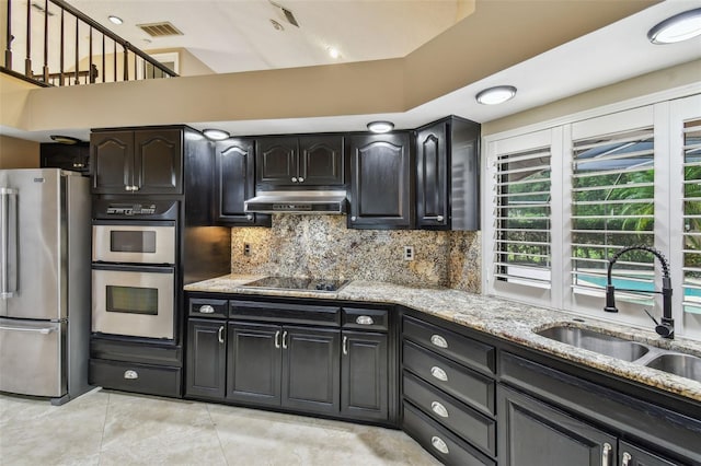 3308 Landing Pl, Palm Harbor, FL 34684 - kitchen featuring appliances with stainless steel finishes, a sink, light stone countertops, ventilation hood, and decorative backsplash