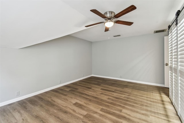 3308 Landing Pl, Palm Harbor, FL 34684 - additional living space featuring a barn door, wood finished floors, and baseboards