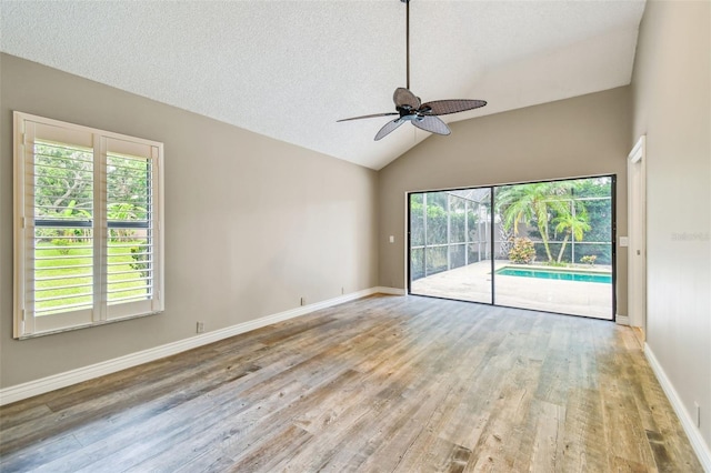 3308 Landing Pl, Palm Harbor, FL 34684 - spare room featuring ceiling fan, wood finished floors, lofted ceiling, baseboards, and a textured ceiling