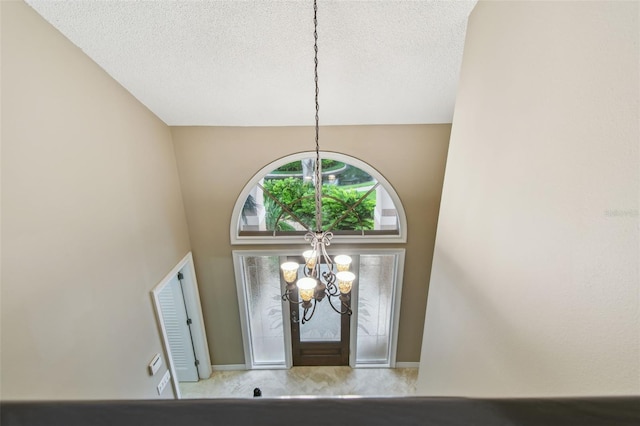 3308 Landing Pl, Palm Harbor, FL 34684 - foyer entrance with a chandelier, a textured ceiling, a towering ceiling, carpet flooring, and baseboards