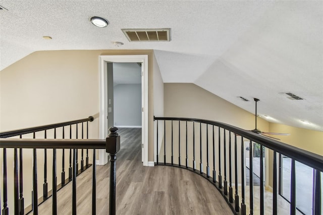 3308 Landing Pl, Palm Harbor, FL 34684 - hallway featuring an upstairs landing, lofted ceiling, wood finished floors, and a textured ceiling