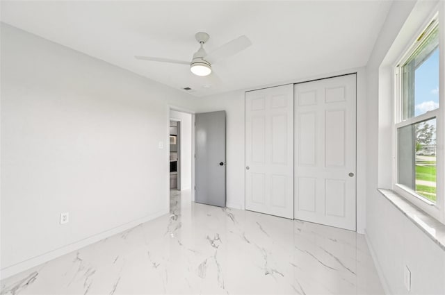 7930 Jeffery Ave, North Port, FL 34287 - unfurnished bedroom with baseboards, a closet, marble finish flooring, and a ceiling fan