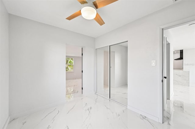7930 Jeffery Ave, North Port, FL 34287 - unfurnished bedroom with marble tiled floors, a closet, baseboards, and a ceiling fan