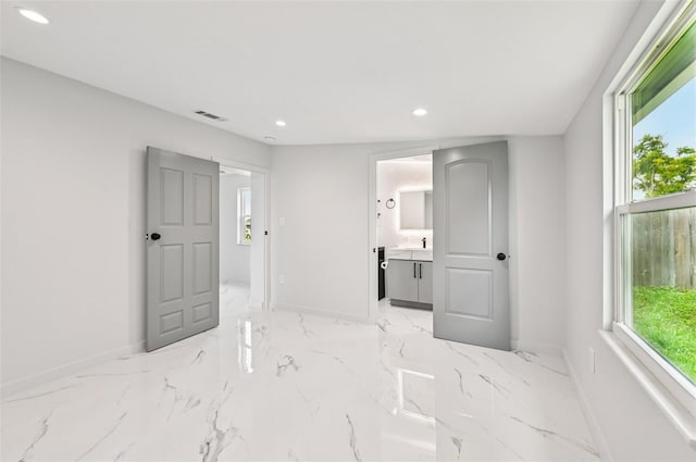 7930 Jeffery Ave, North Port, FL 34287 - unfurnished bedroom featuring baseboards, recessed lighting, light marble finish floors, and ensuite bathroom