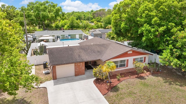 7276 21st St N, Saint Petersburg, FL 33702 - ranch-style home featuring an attached garage, roof with shingles, brick siding, central AC, and a fenced backyard