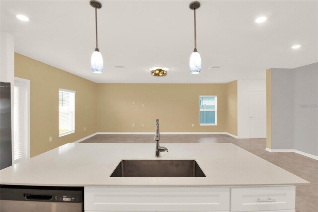 271 Inman Blvd, Winter Haven, FL 33881 - kitchen featuring stainless steel dishwasher, a sink, open floor plan, light countertops, and pendant lighting