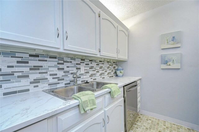 4801 Airport Rd Unit 211, Zephyrhills, FL 33542 - kitchen featuring a sink, tasteful backsplash, a textured ceiling, stainless steel dishwasher, and baseboards