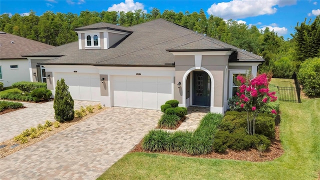 4155 Barletta Ct, Wesley Chapel, FL 33543 - view of front facade featuring stucco siding, a garage, decorative driveway, and a shingled roof