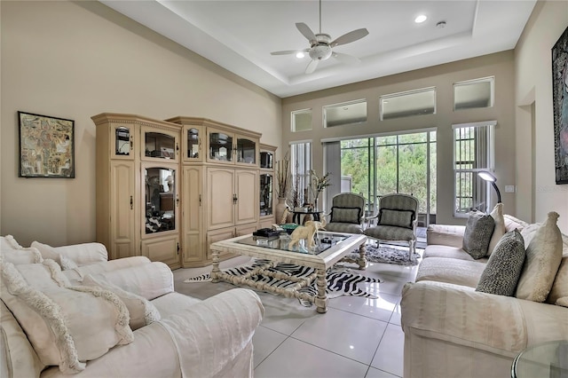 4155 Barletta Ct, Wesley Chapel, FL 33543 - living room featuring a high ceiling, ceiling fan, light tile patterned floors, and a tray ceiling