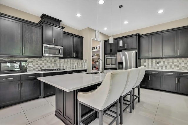 4155 Barletta Ct, Wesley Chapel, FL 33543 - kitchen with appliances with stainless steel finishes, a sink, light tile patterned floors, decorative backsplash, and recessed lighting