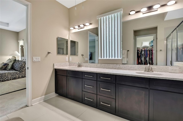 4155 Barletta Ct, Wesley Chapel, FL 33543 - ensuite bathroom with double vanity, a walk in closet, baseboards, a stall shower, and tile patterned floors